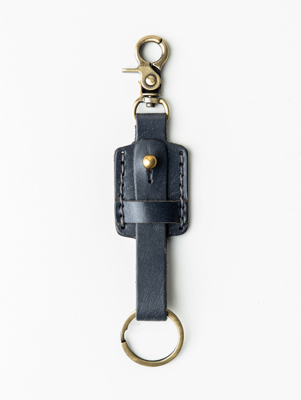 Black leather key fob with gold hardware on a white background